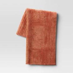 an orange towel folded on top of a white surface with no one in the photo