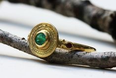 "Beautiful solid gold ring for women in an antique style, with an emerald and 2 rubies, boho engagement ring in 14k, 18k or 22 solid yellow, white, or rose gold. This stunning solid white gold ring has a magnificent natural Green big Emerald set in a decorated circular base. Two small rubies are set in a delicate horseshoe element- one on each side of the rings' band. The ring's vintage-style design combined with vivid colors of the Emerald and Rubies gives this ring a rare and bold beauty. This Traditional Yellow Gold Emerald Ring Gift, Traditional Gold Emerald Anniversary Ring, Traditional Yellow Gold Round Emerald Ring, Traditional Yellow Gold Emerald Ring, Byzantine Gold Emerald Ring For Anniversary, Byzantine Gold Emerald Anniversary Ring, Byzantine Yellow Gold Emerald Ring For Anniversary, Byzantine Style Yellow Gold Emerald Ring For Anniversary, Byzantine Style Emerald Ring In Yellow Gold