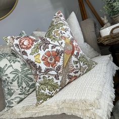 several pillows on a couch in a room with other furniture and decor items around them