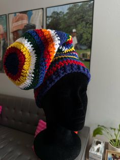 a crocheted multicolored hat sits on a mannequin's head