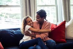 two women sitting on a couch hugging each other