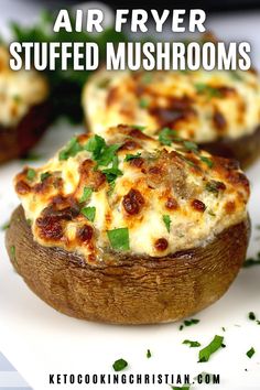 an air fryer stuffed mushroom with cheese and parsley on top, sitting on a white plate