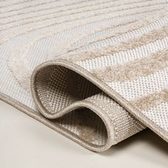 a close up view of a rug on the floor with white and beige carpeting