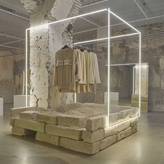 an empty room with clothes on display in it