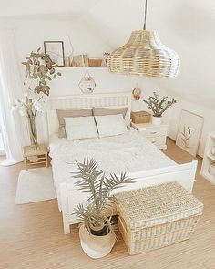 a bedroom with white bedding and wicker baskets hanging from the ceiling above it