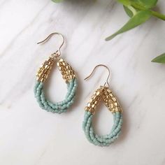 two pairs of white and gold beaded earrings on top of a marble countertop