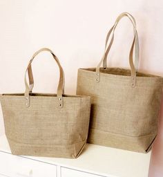 Product Description: These jute tote bags are a great way to package your bridesmaid gifts or to hand out at your bachelorette party! Each jute bag features leather handles, a zipper closure, and an inside pocket, and comes personalized with a script name in white vinyl. Choose from two bag sizes. Material: 100% burlap jute fabric. PLEASE NOTE: Sold individually, NOT as a set of two bags. Non-personalized. A personalized version is available as Product Code: EM-3330ANS. Wish Box, Jute Tote Bags, Jute Fabric, Jute Totes, Cake Accessories, Jute Bag, A Script, Personalized Cups, Jute Bags