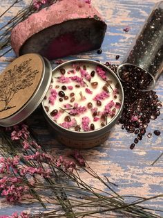 two tins filled with white and pink flowers on top of a blue wooden table