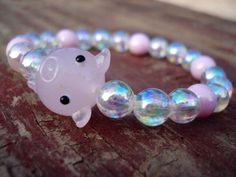 "\"Carnival Pig\" 24x14 Glass Pig Bead 8mm iridescent and pink glass beads Spiritual Meaning of: Opal Color - glory, heavenly, favor, manifold pink- is feminine and romantic, affectionate and intimate, thoughtful and caring. Pig - moves swiftly and with determination. It intuitively knows the best reaction to various situations. STANDARD SIZE FOR MEN IS 8\" AND FOR WOMEN 7\" PLEASE NOTE.... IF YOU DO NOT KNOW YOUR WRIST SIZE, SIMPLY PUT A PIECE OF STRING AROUND YOUR WRIST (in between your wrist Pink Crystal Bracelet With 8mm Beads For Party, Kawaii Pink Beaded Bracelets With Round Beads, Kawaii Round Beads Jewelry Gift, Pink Round Beads Kawaii Jewelry, Novelty Pink Beaded Jewelry, Pink Novelty Beaded Jewelry, Pink Beaded Novelty Jewelry, Novelty Pink Bracelets With Round Beads, Kawaii Pink Bracelet For Party