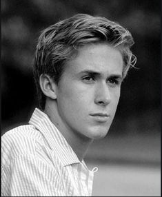 black and white photograph of a young man with short hair wearing a striped shirt looking at the camera