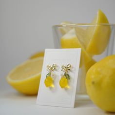 a pair of lemon earrings sitting on top of a table