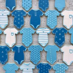 cookies decorated with blue and white onesuits are arranged on a wooden table top