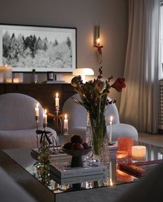 a living room filled with lots of furniture and candles on top of a coffee table