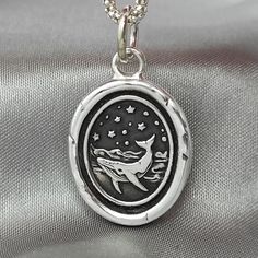 "Whale Ocean Celestial Wax Seal Necklace Pendant, Handmade Sterling Silver, Intaglio Seal Heirloom, Original Design Liliane Ting 072 This wax seal captures the majesty of a whale in its oceanic realm. Carry it as a reminder of the vast depths of life's adventures and the profound beauty that can be found when you venture into the unknown. ♥ About the work: All jewelry are handmade using the original seal made at Liliane Ting Studio located in Murfreesboro, Tennessee.  Made with recycled sterling silver to make our products more sustainable. >>Size: 24 * 22 mm excluding bail  >>Material: Solid Sterling Silver >>Pendant Only Option: You may order \"Pendant Only\".  This charm comes on a 5 mm sterling jump ring that you may thread onto your own necklace chain.  >>Chain Options: The sterling s Celestial Silver Oval Pendant Jewelry, Celestial Sterling Silver Oval Pendant Jewelry, Adjustable Silver Necklace With Ocean-inspired Style, Silver Ocean-inspired Pendant Jewelry, Ocean-inspired Sterling Silver Charm Necklaces, Seal Necklace, Wax Seal Necklace, Murfreesboro Tennessee, Whale Necklace