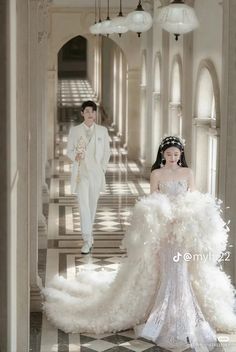 a man and woman walking down a hall in formal wear, one wearing a wedding dress