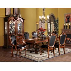 a dining room table with chairs and a china cabinet