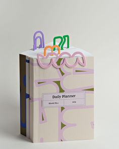 an open book with the word daily planner written in multicolored letters on it