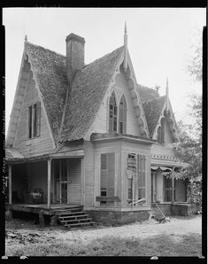 an old house with a thatched roof and two story porches on the front