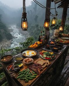 a table with food on it and some lights hanging from the ceiling next to water