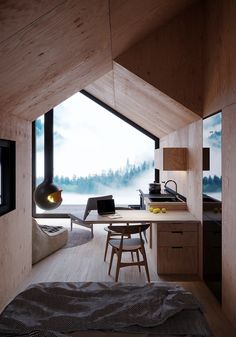 a bedroom with wooden walls and flooring next to a window that looks out onto a lake