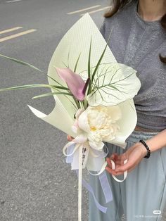 a woman holding a bouquet of flowers on the street