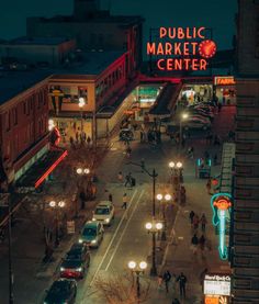 an overhead view of a city street at night with cars and people walking on the sidewalk