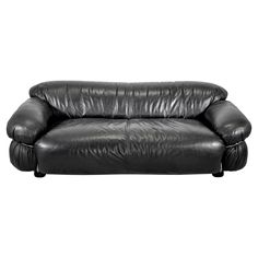 a black leather couch sitting on top of a white floor