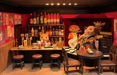 three stuffed animals are sitting at a bar