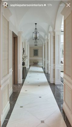 a long hallway with white walls and columns