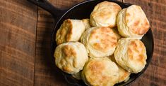 a skillet filled with biscuits on top of a wooden table