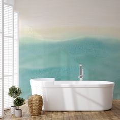 a bathtub sitting on top of a wooden floor next to a potted plant