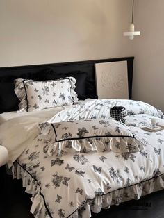 a bed with white sheets and black pillows