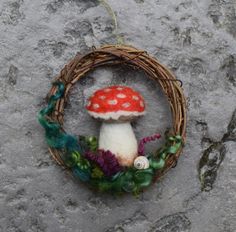 a small mushroom sitting on top of a mossy wreath next to a stone wall