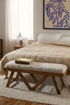 a bed sitting in a bedroom next to a white rug on top of a wooden floor