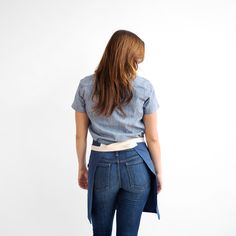 a woman in jeans is standing with her back to the camera and looking at something