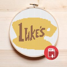 a cross - stitch pattern with the word lakes in yellow and brown on a white hoop