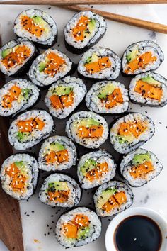 sushi rolls with carrots and avocado on top