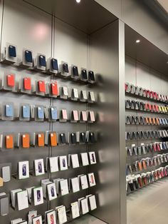 a display case with many different cell phones on the wall and hanging from it's sides