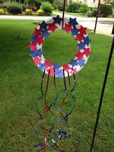 a wreath made out of red, white and blue paper streamers in the grass