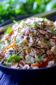 a blue bowl filled with rice and vegetables