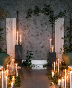 candles and greenery are arranged on the floor