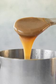 caramel sauce being poured into a silver pot