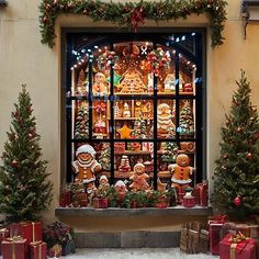 a window display with christmas decorations and gifts in front of it, surrounded by small trees