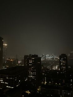 the city skyline is lit up at night with bright lights in the sky and buildings below