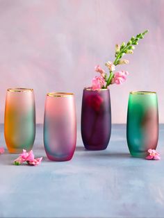 three different colored vases with flowers in them