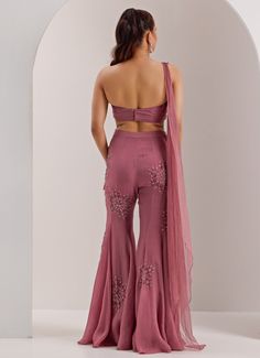 Elevate your evening wardrobe with the exquisite elegance of Lilac One Shoulder Draped Blouse with Pant. Crafted from a luxurious mix of organza and shimmer chiffon, this Lilac blouse features an asymmetric shoulder design, and back drape gracefully complemented by intricate mix media embroidery that adds a touch of sparkle. Paired with high-waisted, flared pants, this set provides a sleek yet comfortable fit. Ideal indo western style for Mehndi, Sangeet or as wedding guest attire. Composition : Pant, Blouse - Organza, Shimmer Chiffon and Shantoon Care: Dry Clean Only and Vacuum Storage This product can be customized for sleeves, blouse length and neckline Delivery : 4-6 weeks as the product is hand crafted. Check Size Guide or choose MySize for free customisation (All Sizes above XL can b Blouse Organza, Lilac Blouse, Wedding Guest Attire, Vacuum Storage, Draped Blouse, Guest Attire, Sleeves Blouse, Wedding Attire Guest, Indo Western