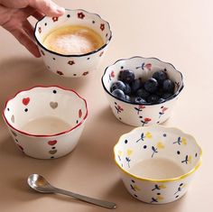 three bowls with blueberries in them and a spoon next to one bowl filled with berries