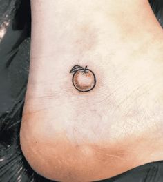 a small apple tattoo on the ankle