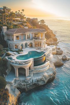 an aerial view of a house with a pool in the foreground and ocean behind it