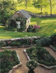 an aerial view of a garden in the middle of a grassy field with a house and fence